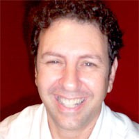 JC Strong Smiling man with short, dark curly hair